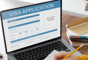 Person filling online visa application form on laptop - RCEC